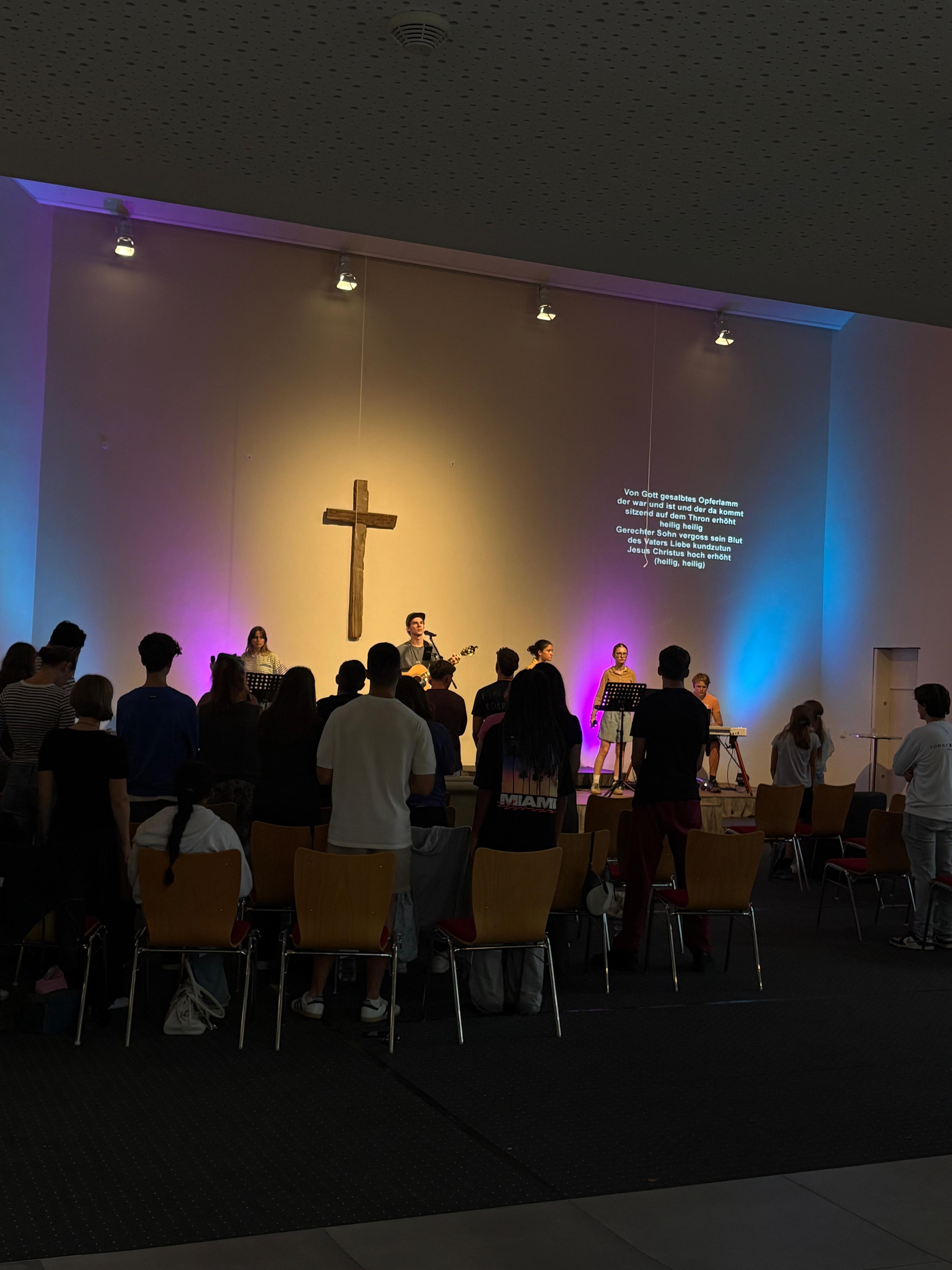 Gemeinschaft beim Lighthouse-Gottesdienst, von hinten mit Blick auf das Kreuz